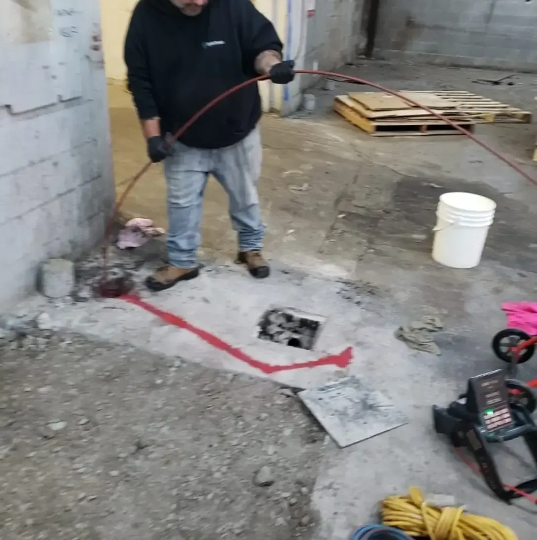 Un homme en chemise noire tient un tuyau