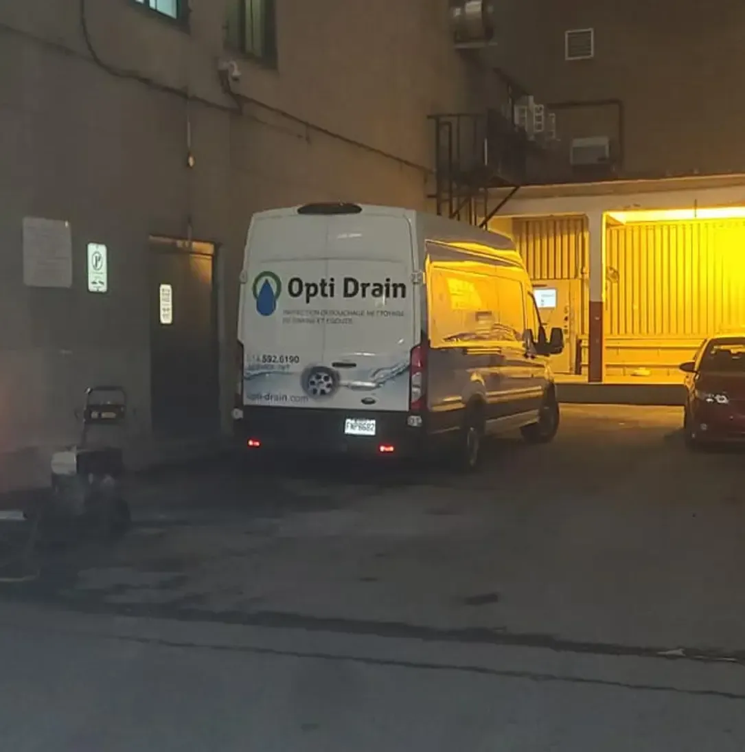Une camionnette Optidrain est garée sur un parking