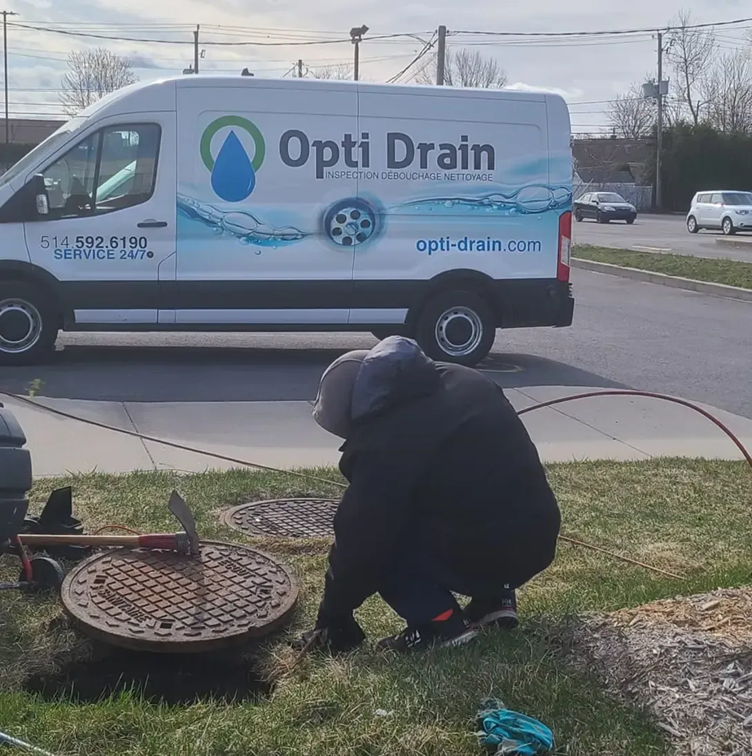 Un homme est agenouillé devant une camionnette de vidange opti