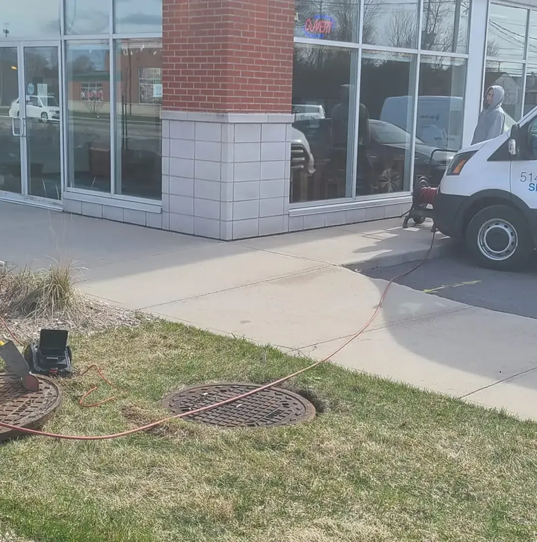 Une camionnette blanche est garée devant un bâtiment.