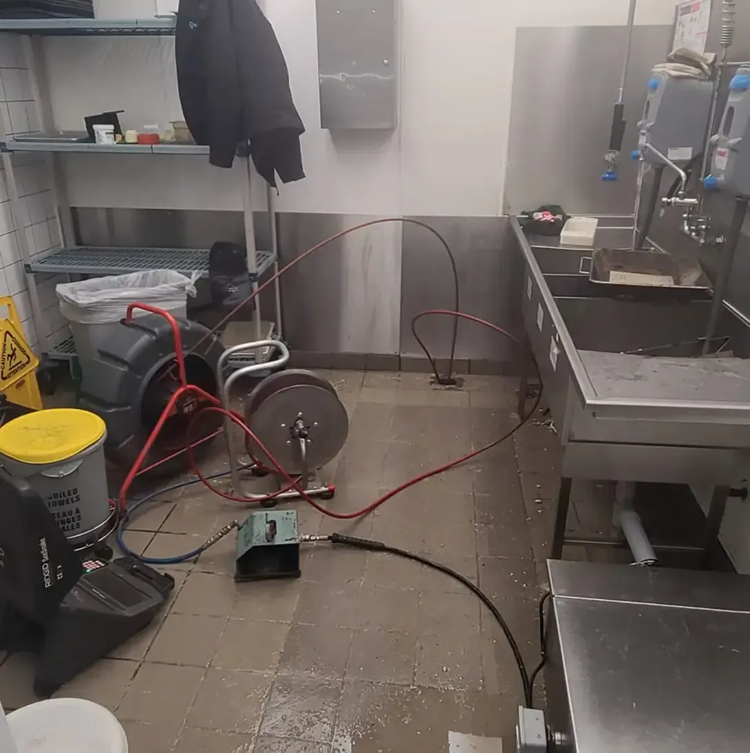 Une cuisine en désordre avec un évier et un aspirateur.