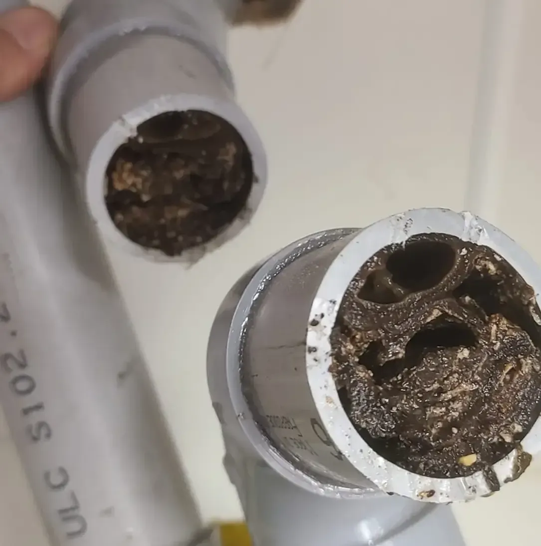 Une personne tient un tuyau sur lequel est écrit ulc