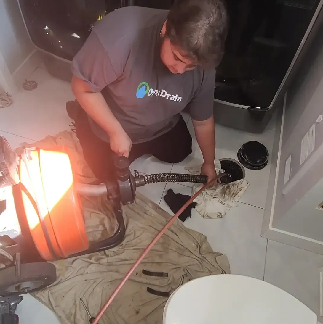 Un homme portant une chemise sur laquelle est écrit « geo drains » travaille sur un drain