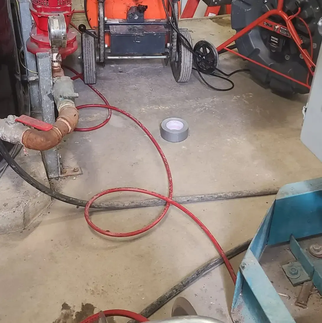 Un aspirateur est posé sur le sol à côté d'un tuyau.