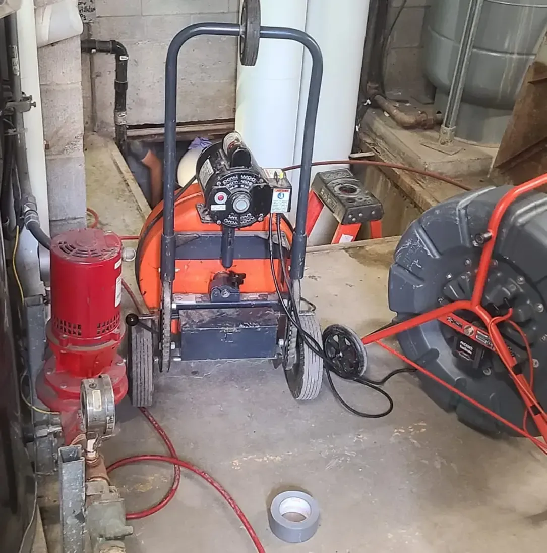 Un enrouleur de tuyau est posé sur le sol à côté d'une pompe