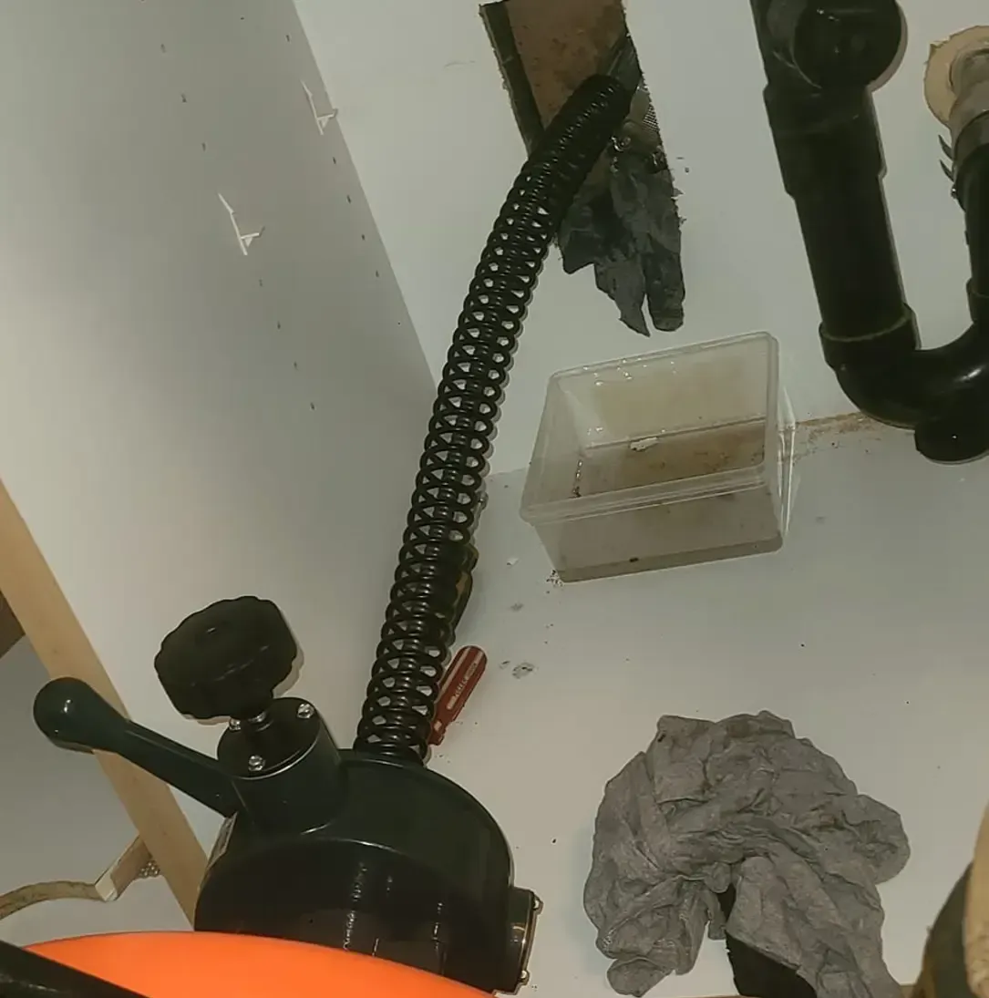 Un déboucheur de canalisations est placé sous un évier dans une salle de bain