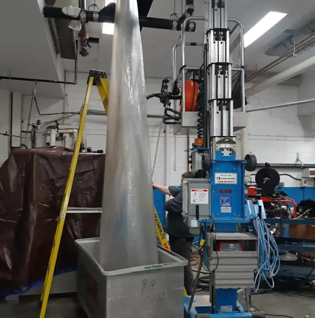 Une machine bleue avec une échelle jaune devant elle