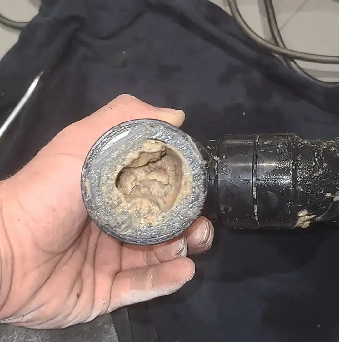 Une personne tient un tuyau avec un trou dedans