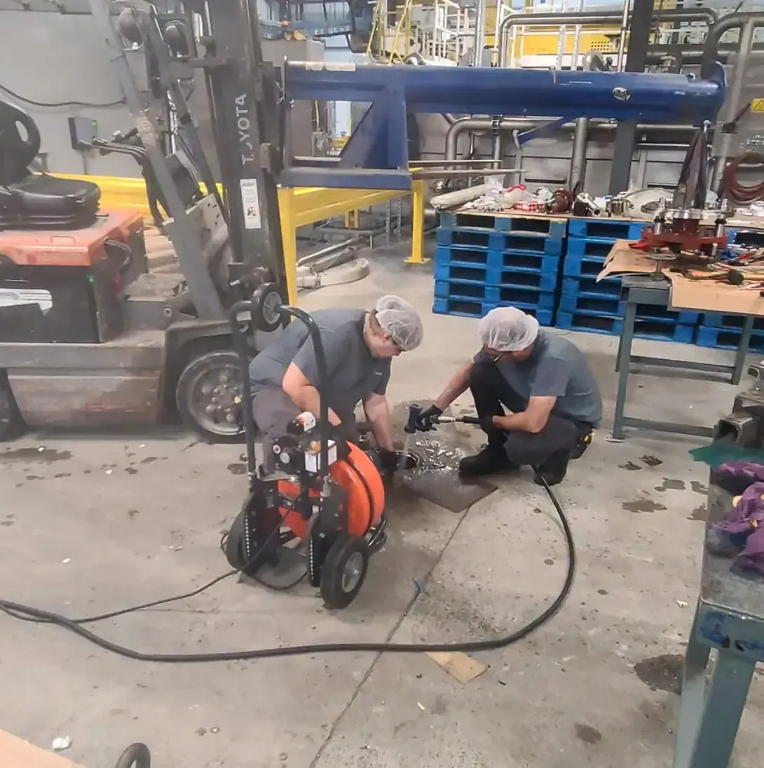 Deux hommes travaillent sur un chariot élévateur dans une usine