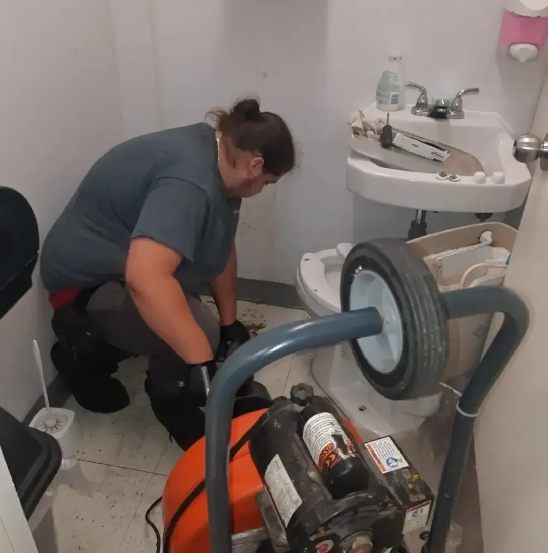 Un homme travaille sur des toilettes dans une salle de bain