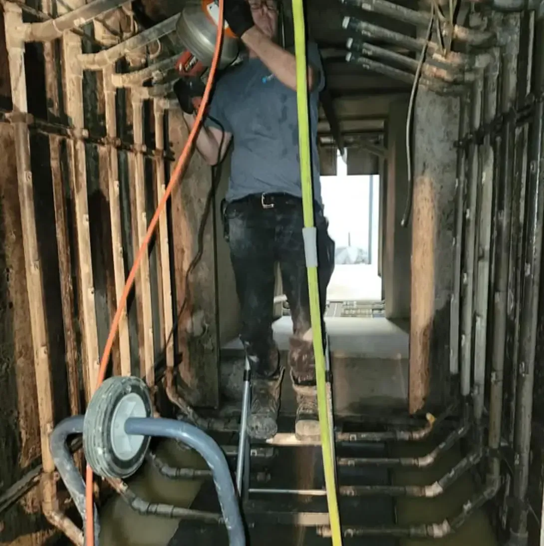 Un homme travaille sur un tuyau dans un bâtiment