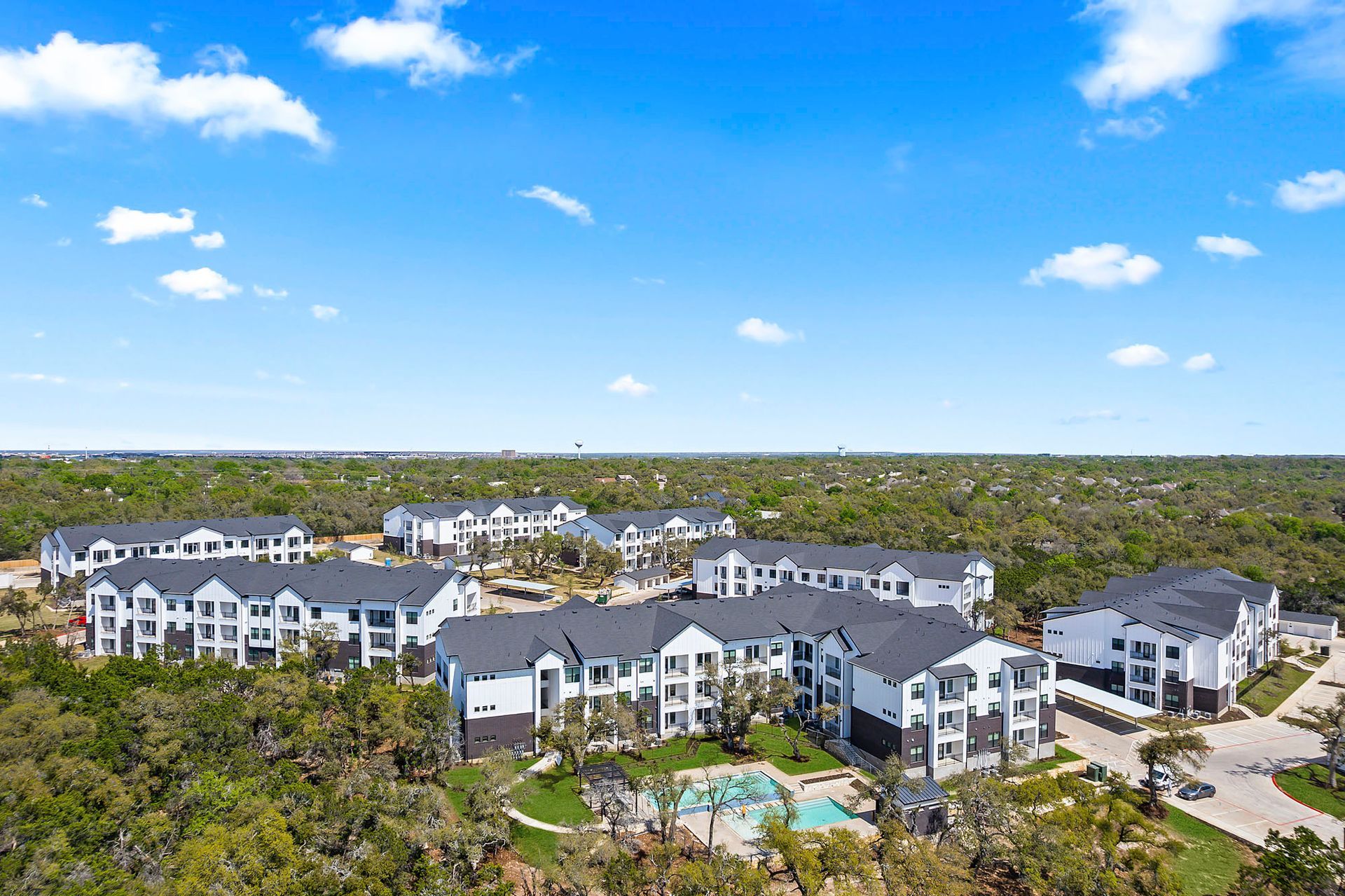 An aerial view of a large apartment complex surrounded by trees at The Everett, offering apartments for rent near The Domain.