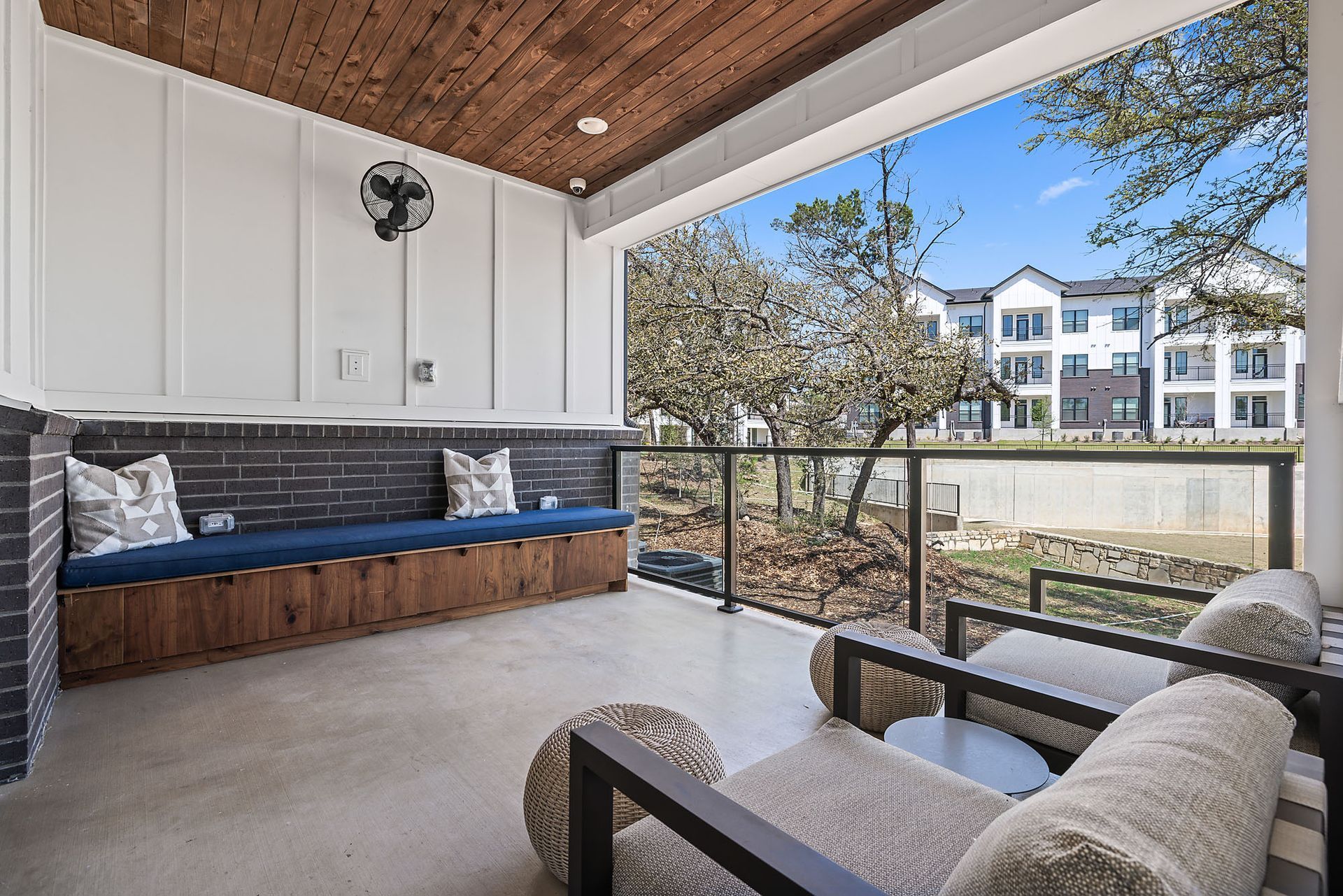 There is a spacious balcony with a bench and chairs on it at The Everett, offering apts in Northwest Austin, TX.