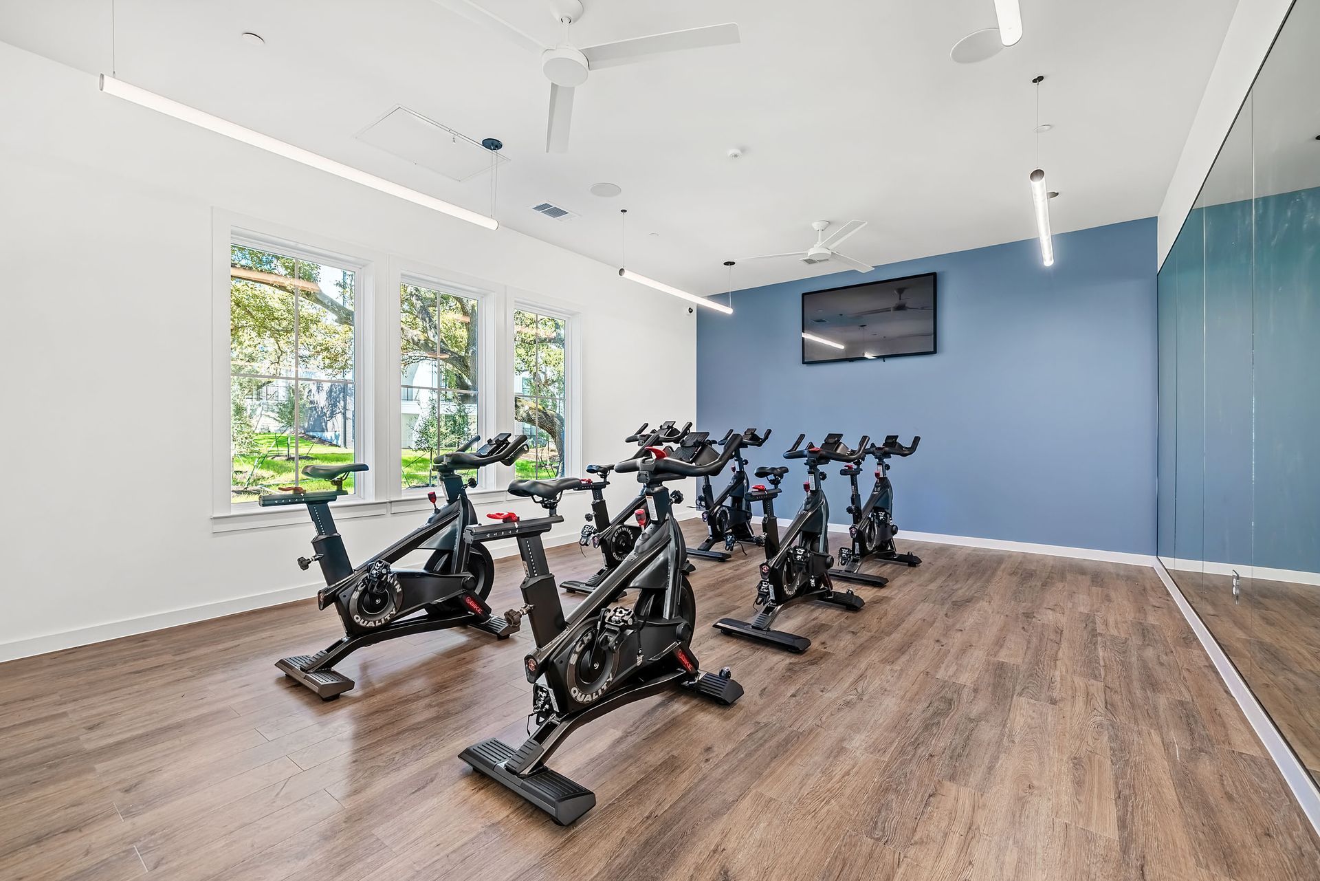 A gym with a lot of exercise bikes and a large mirror at The Everett. offering apartments in Northwest Austin, TX.