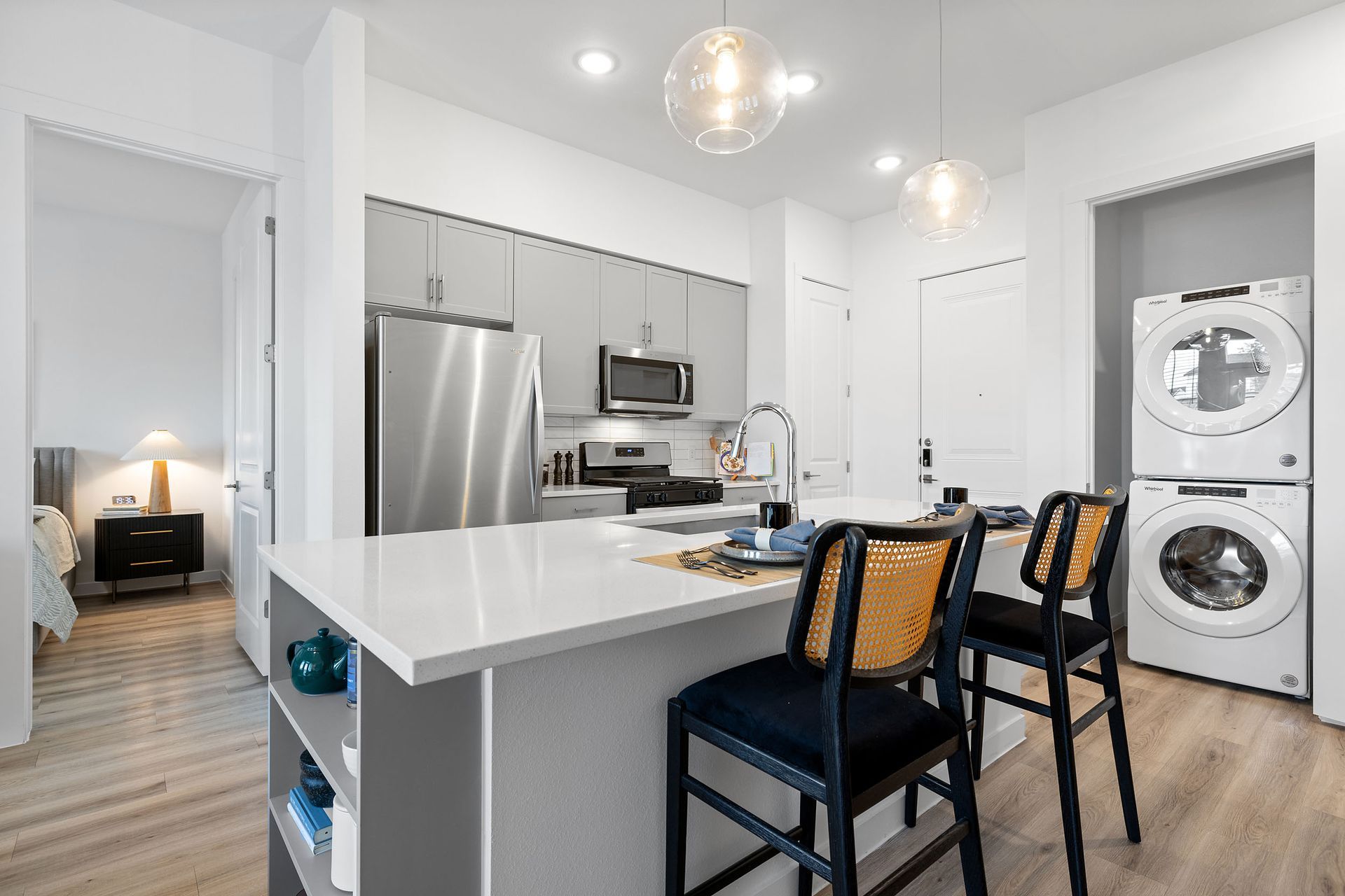 A kitchen with a washer and dryer stacked on top of each other at The Everett, offering apartments for rent in Northwest Austin, TX