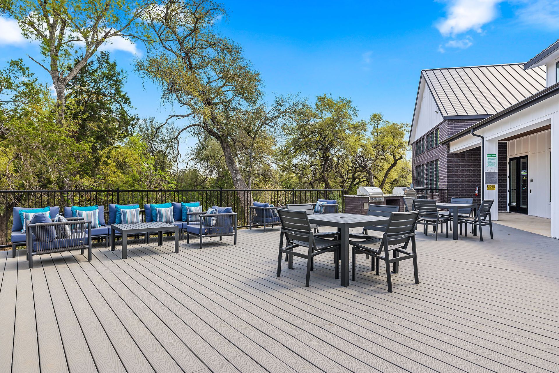 There is a large deck with tables and chairs on it at The Everett, offering apartments in Northwest Austin, TX.