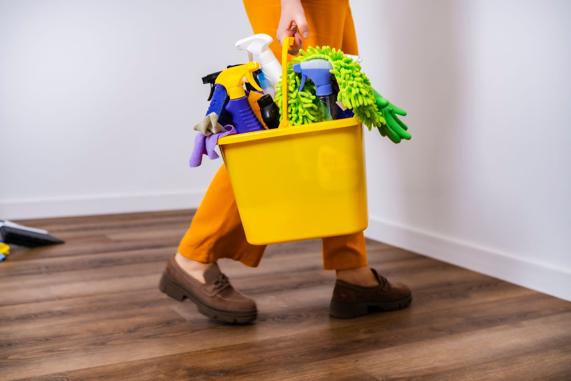 Two movers in blue overalls lifting cardboard boxes in a room; one has a tattoo.