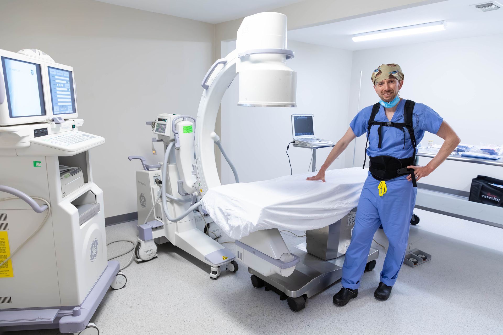 Doctor standing beside a medical imaging scanner in a hospital room