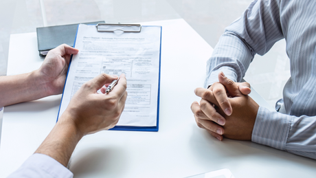 A man and a woman are sitting at a table having a job interview.