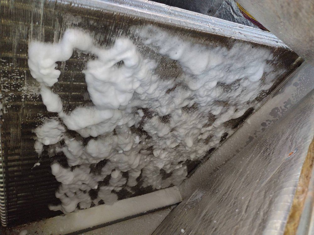 Electrician in safety gear working on a circuit breaker panel.