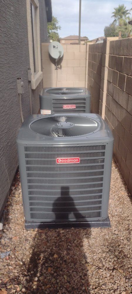 Electrician in blue uniform works on an electrical panel, indoors.