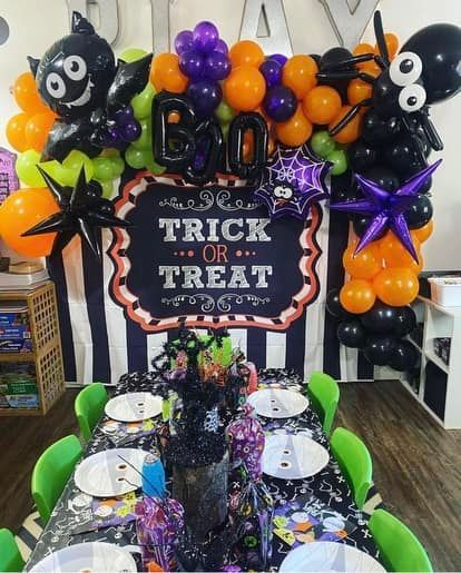 A table with plates and a sign that says trick or treat