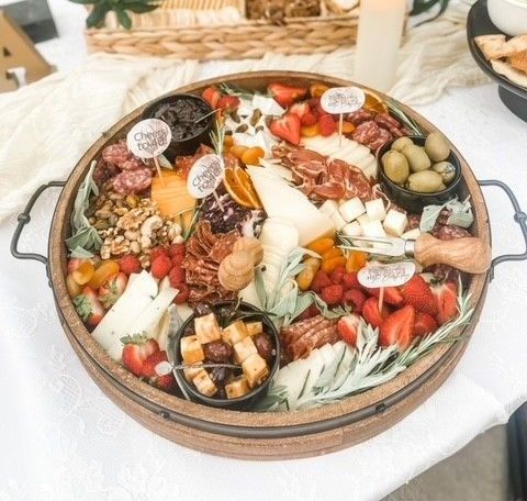 A wooden tray filled with a variety of food on a table.