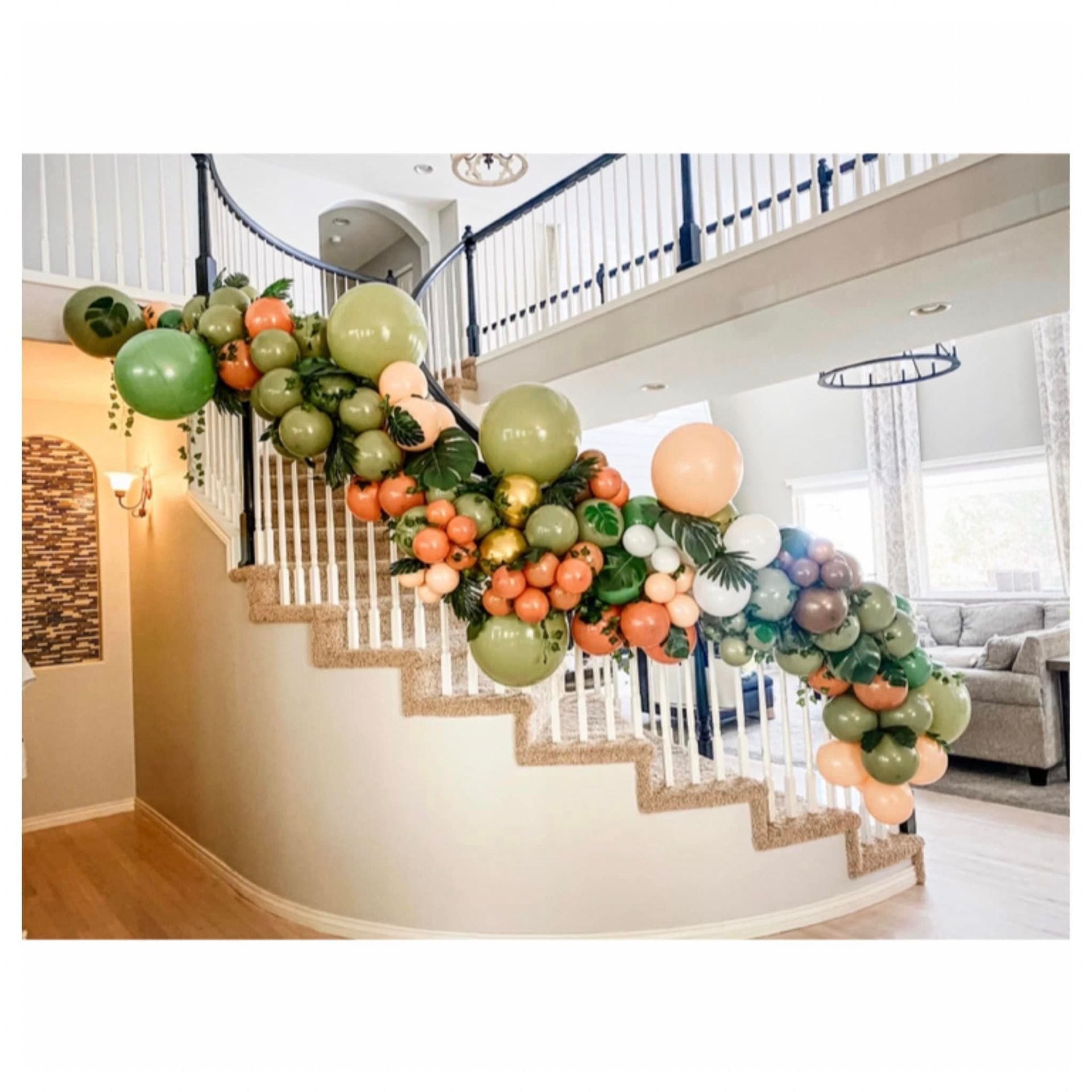 A staircase decorated with balloons in a living room.