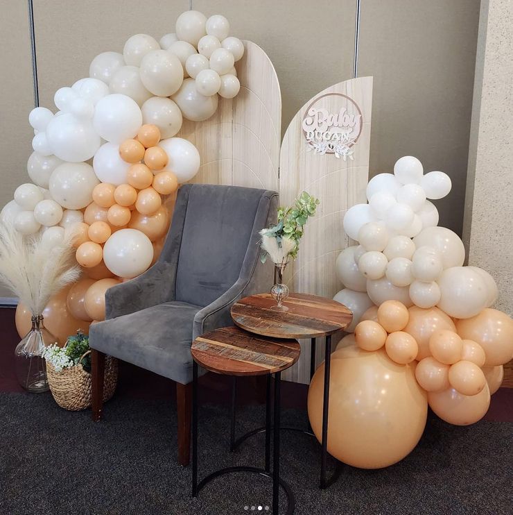 A chair is surrounded by balloons in a room