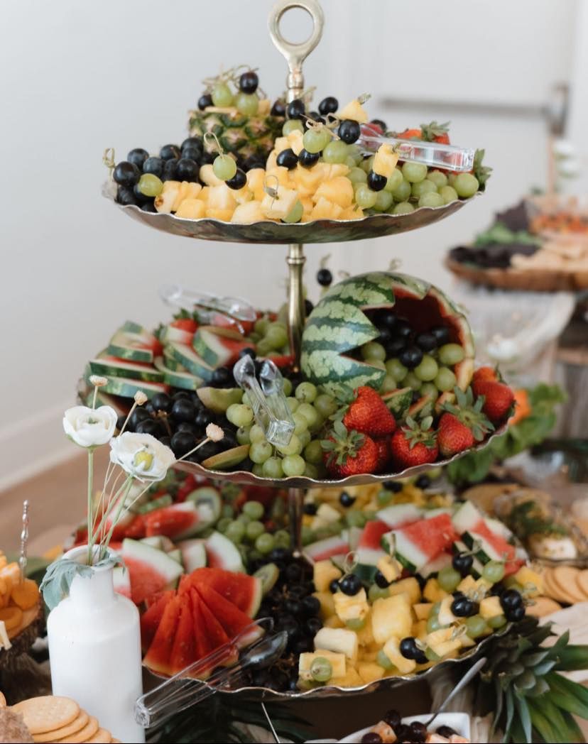 A three tiered tray filled with fruit and vegetables on a table.