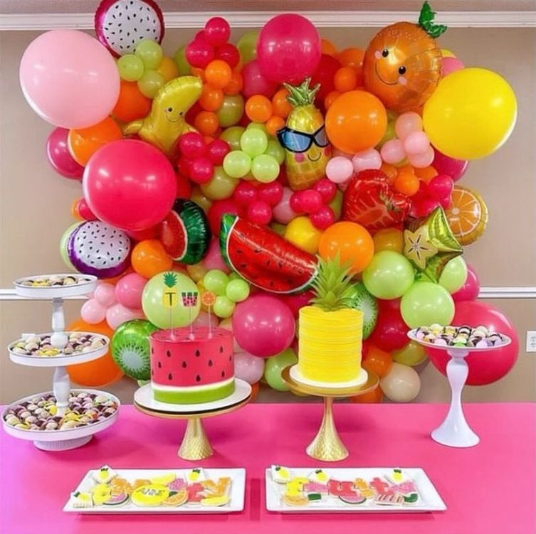 A table with a watermelon cake and a pineapple cake