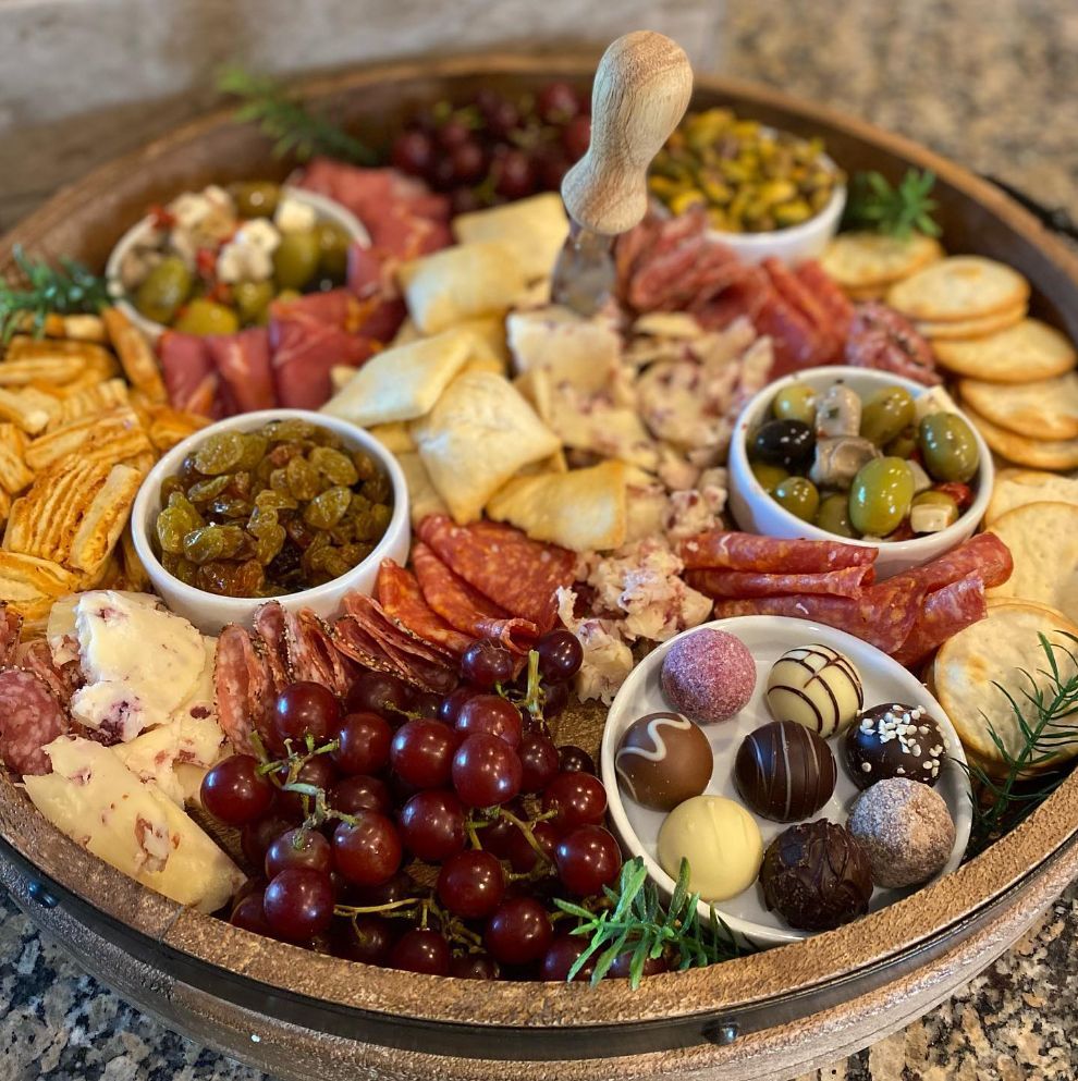 A wooden tray filled with lots of different types of food.