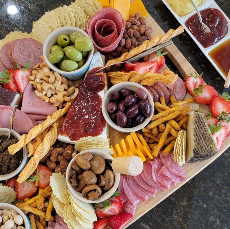 A wooden cutting board filled with lots of different types of food.
