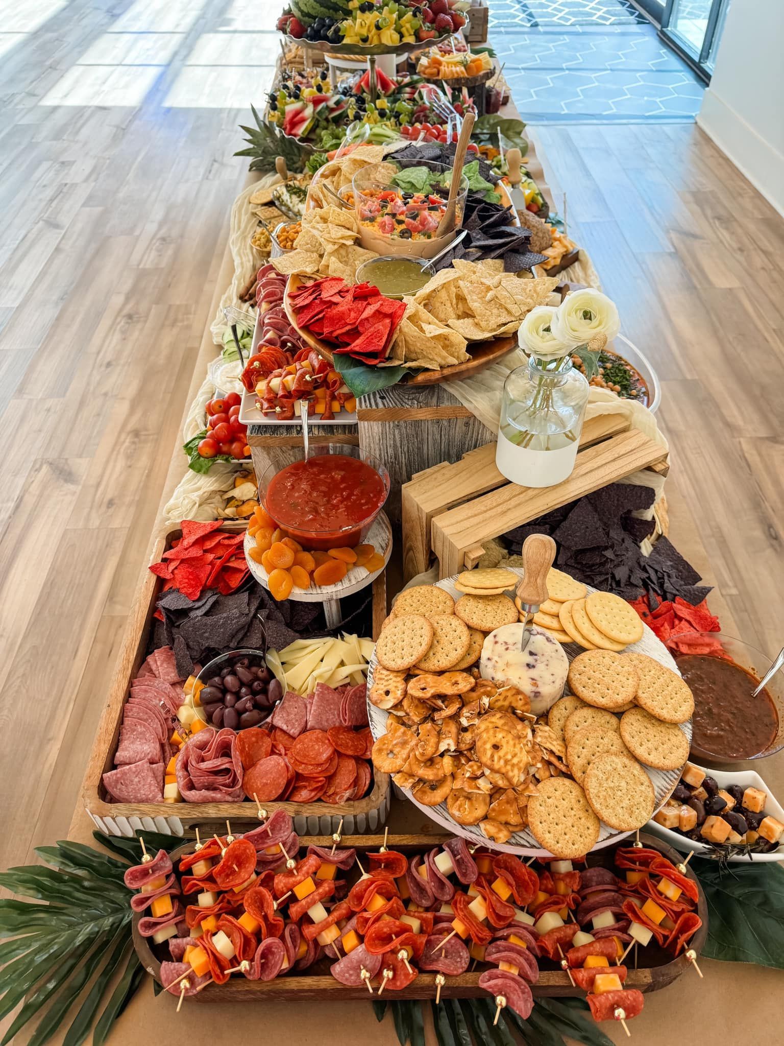 A long table topped with plates of food and crackers.