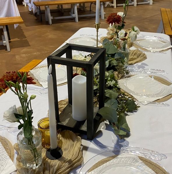 A table with plates flowers and candles on it