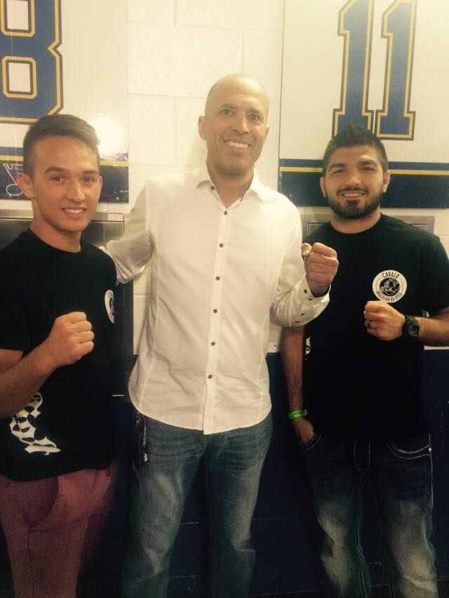 Three men are posing for a picture in front of a wall with the number 11 on it