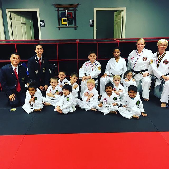 A group of people in karate uniforms are posing for a picture