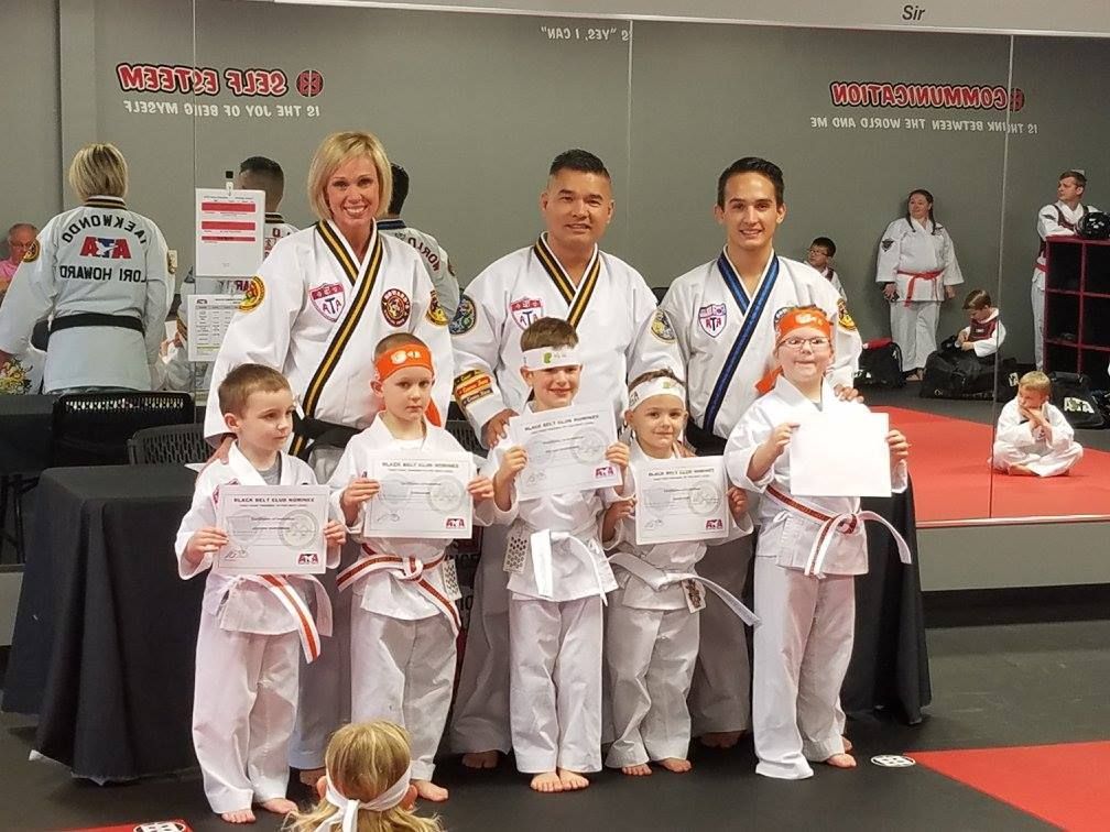 A group of people in karate uniforms are posing for a picture
