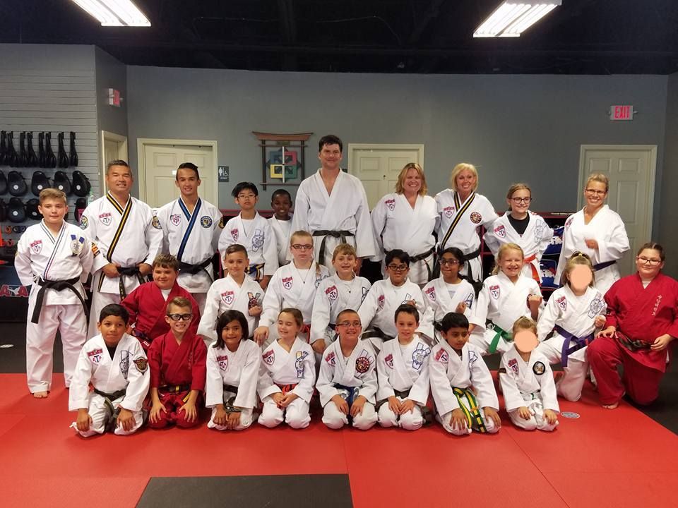 A group of people in karate uniforms are posing for a picture