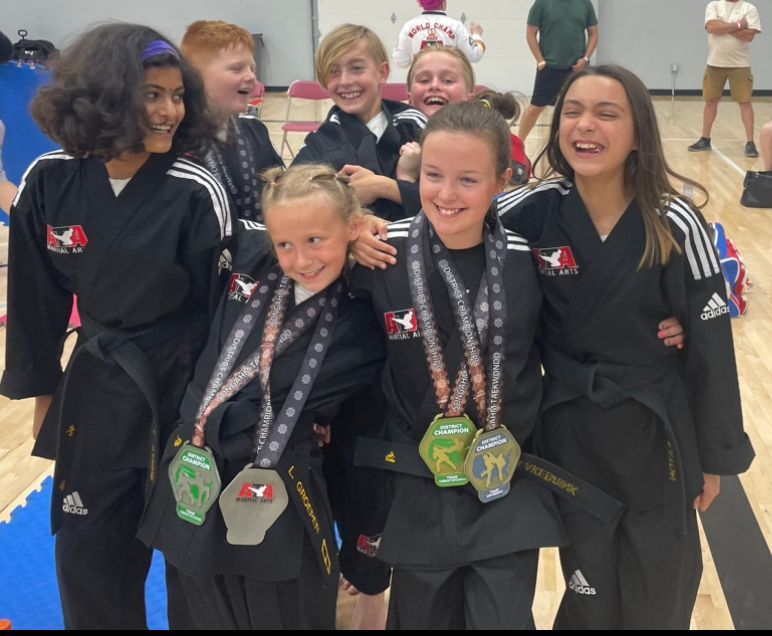 A group of young girls posing for a picture with medals around their necks