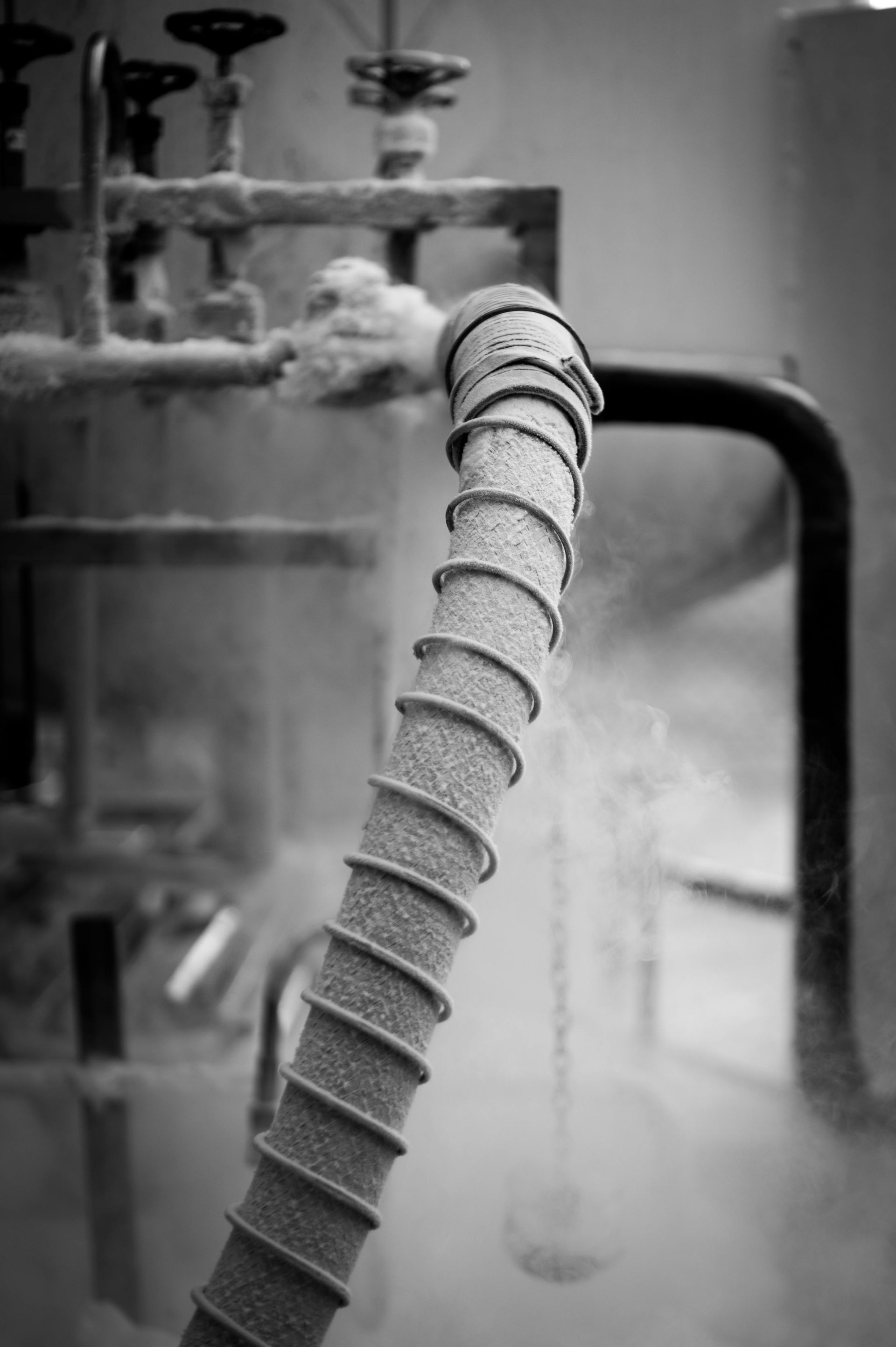 A black and white photo of a hose in a factory.