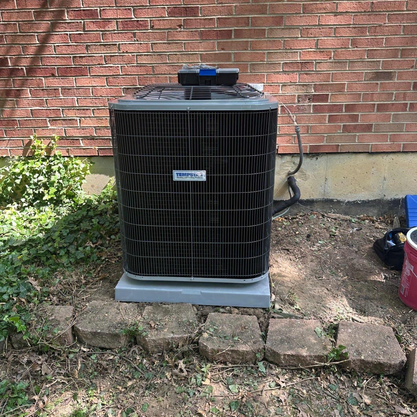 Central air conditioning unit outside a brick building.