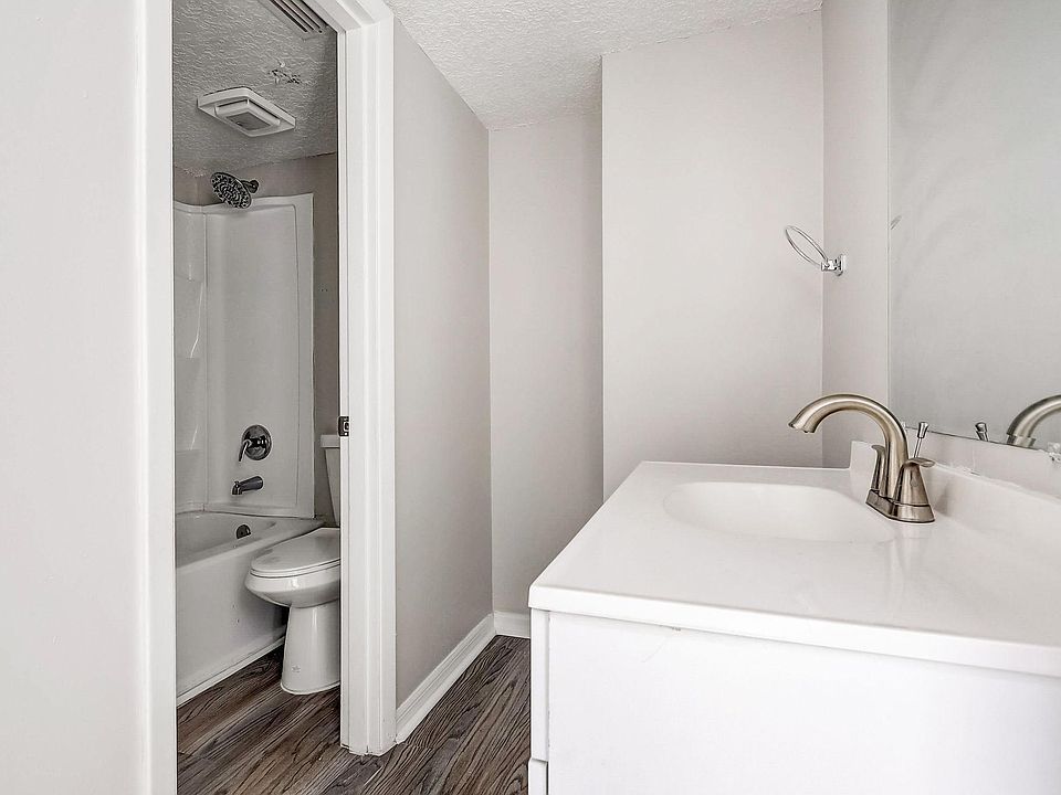 Bathroom with white vanity, sink, and open doorway to shower/toilet area.