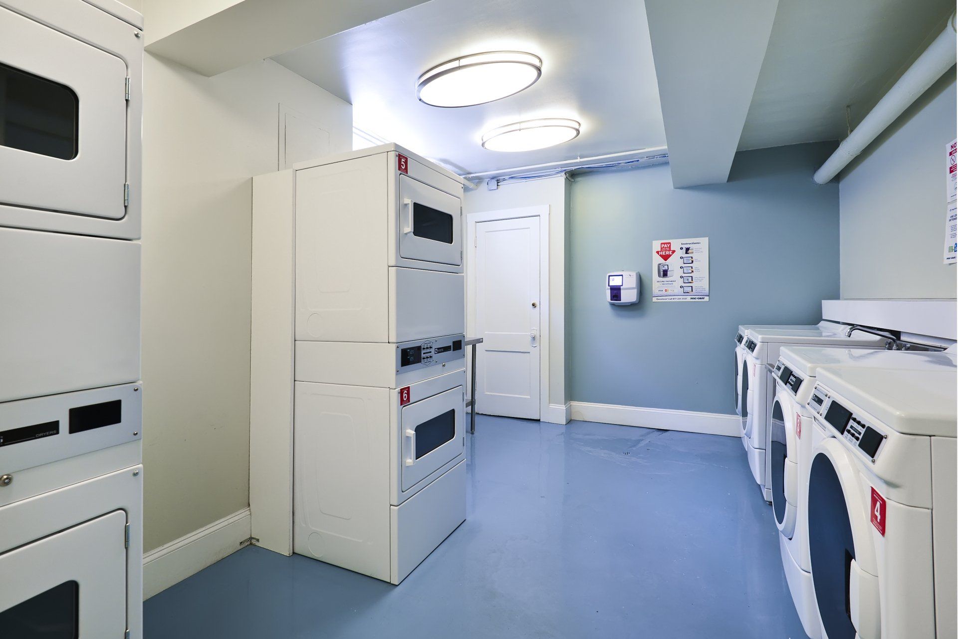 A laundry room with a lot of washers and dryers at Irving Courts by Reside.