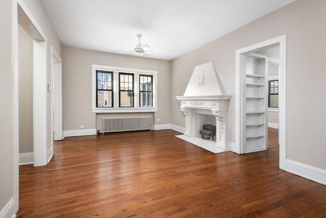 Irving Courts by Reside apartment living room with hardwood floor, windows, and fireplace in Buena Park, Chicago.