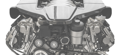 Close-up of a car engine with belts, pulleys, and various mechanical components.
