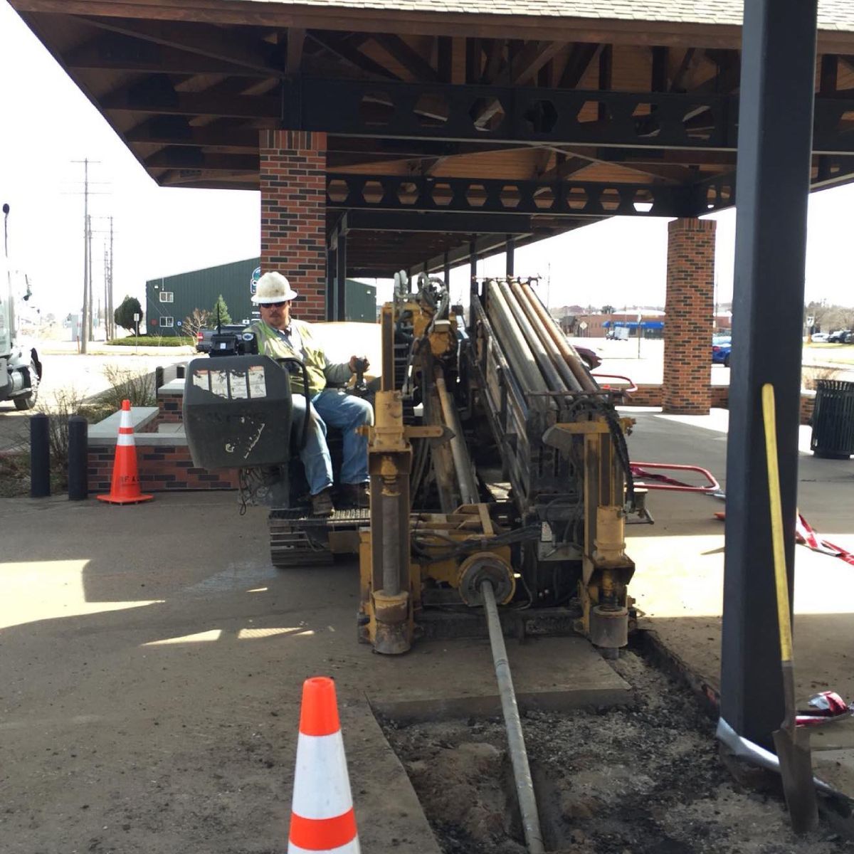 A man in a hard hat is sitting on a machine