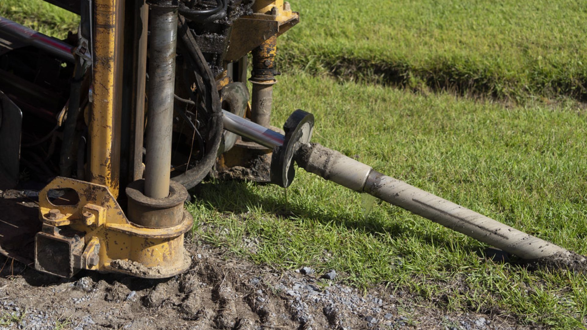 A machine is drilling a hole in the ground in a field.