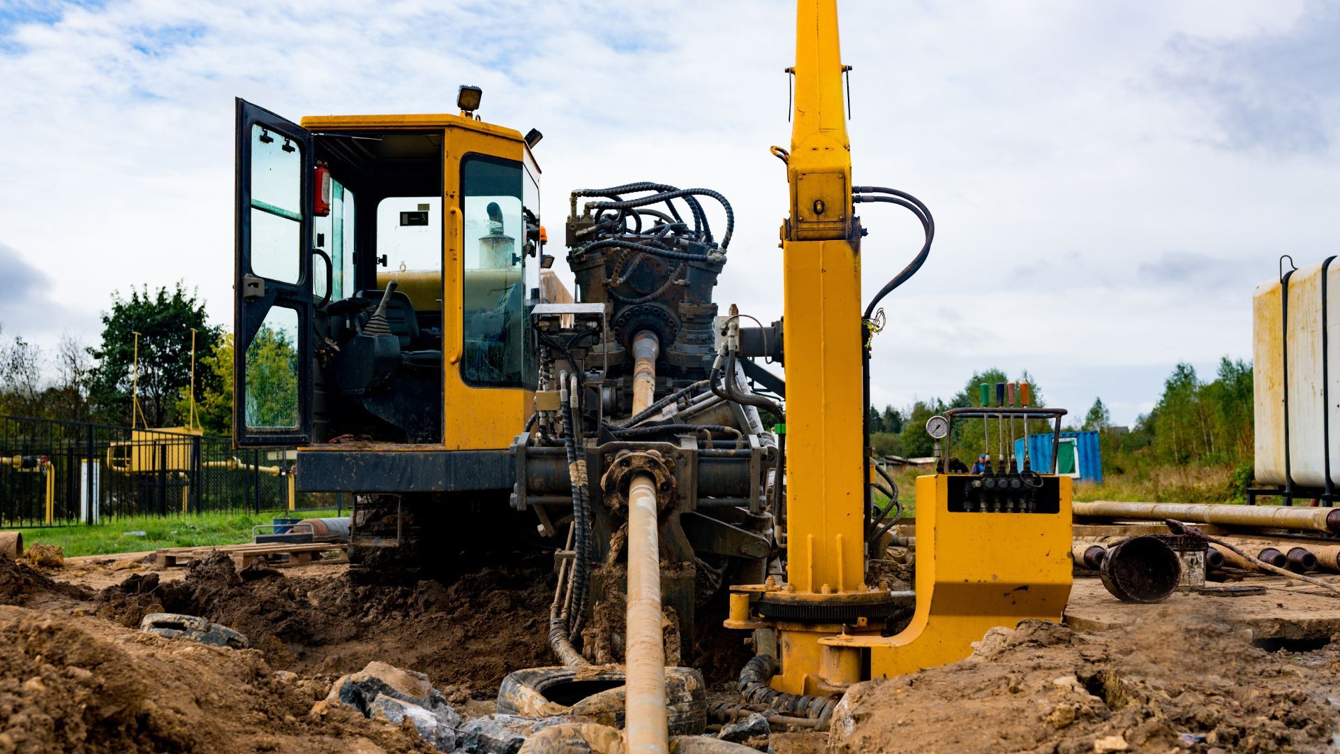 A yellow excavator is digging a hole in the ground.