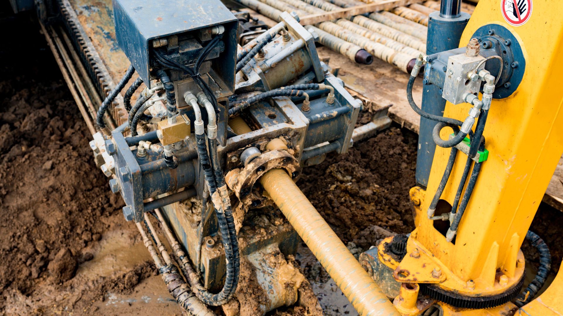 A yellow and black machine is digging a hole in the ground.